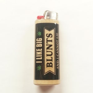May include: A black and wood lighter with a green marijuana leaf and the text "I LIKE BIG BLUNTS AND I CANNOT LIE" printed on the front.