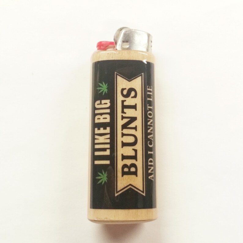May include: A black and wood lighter with a green marijuana leaf and the text "I LIKE BIG BLUNTS AND I CANNOT LIE" printed on the front.