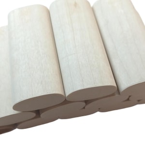 May include: A stack of unfinished, light-colored wooden dowels with rounded edges.