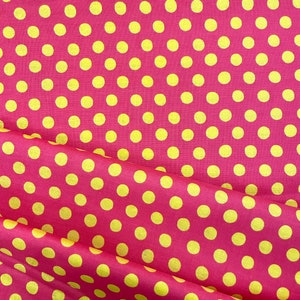 May include: Pink fabric with a yellow polka dot pattern. The fabric is folded in half, showing the pattern on both sides.