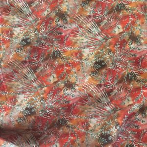 May include: Red, orange, and brown fabric with a white and green floral pattern.