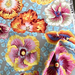 May include: A gray fabric with a floral pattern featuring large hibiscus flowers in shades of pink, yellow, orange, and blue. The fabric is printed with a repeating pattern of small blue circles and lines.