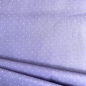 May include: A close-up of a light purple fabric with a white polka dot pattern. The fabric is folded in half, showing the pattern on both sides.