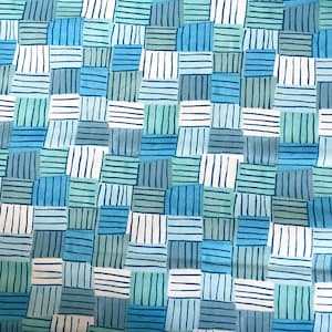 May include: A fabric with a repeating pattern of blue, green, and white striped squares. The squares are arranged in a random pattern.