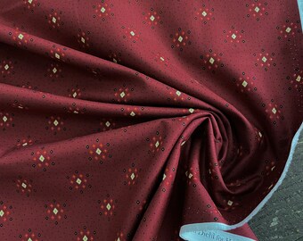 May include: Red fabric with a white and yellow geometric pattern. The fabric has a white border and the text "Diehl for Henry Glass & Co." is printed on the border.