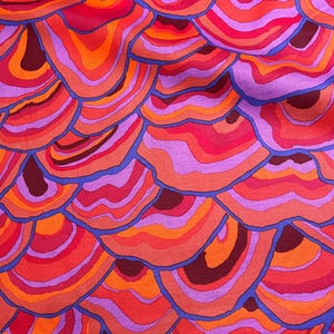 May include: Abstract fabric with a repeating pattern of overlapping, concentric circles in shades of red, orange, purple, and blue.