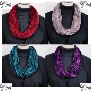 May include: Four infinity scarves in different colors: burgundy, gray, teal, and purple. The scarves are made of a soft, fuzzy material and are perfect for keeping warm in the winter.