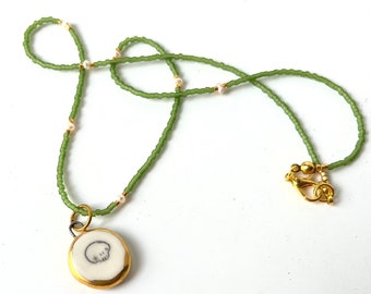 Olive green and real seed pearls bead necklace with white and gold skull pendant