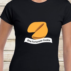 May include: Black t-shirt with a graphic of a fortune cookie and the text "One Fortunate Cookie".