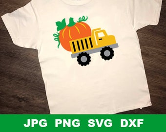 Op de afbeelding: Een wit T-shirt met een gele vrachtwagen die een grote oranje pompoen vervoert. De vrachtwagen heeft zwarte wielen en een groene steel op de pompoen.