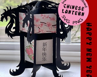 May include: Black Chinese lantern with a dragon design and a pink and white floral pattern. The lantern has a base with four legs and says "Happy New Year" in Chinese characters.