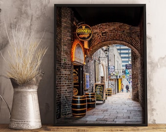 May include: A narrow, brick-lined alleyway in Dublin, Ireland. A sign for a bar and restaurant reads "Bar & Restaurant". A Guinness sign hangs above the entrance. The alleyway is lined with barrels and leads to a cobbled street.