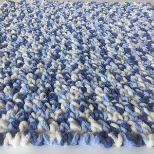May include: A soft, blue and white knitted baby blanket with a fluffy texture.