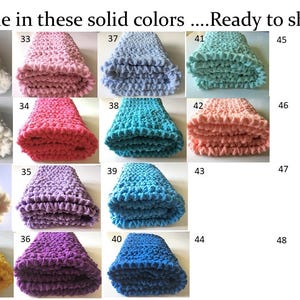 Puede incluir: Una colecci&oacute;n de 20 mantas de ganchillo en varios colores s&oacute;lidos, incluyendo blanco, rosa, rojo, morado, azul y amarillo. Las mantas est&aacute;n dobladas y dispuestas en una cuadr&iacute;cula. Cada manta est&aacute; etiquetada con un n&uacute;mero del 29 al 48.
