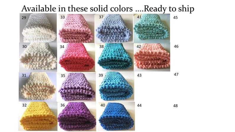 Puede incluir: Una colecci&oacute;n de 20 mantas de ganchillo en varios colores s&oacute;lidos, incluyendo blanco, rosa, rojo, morado, azul y amarillo. Las mantas est&aacute;n dobladas y dispuestas en una cuadr&iacute;cula. Cada manta est&aacute; etiquetada con un n&uacute;mero del 29 al 48.