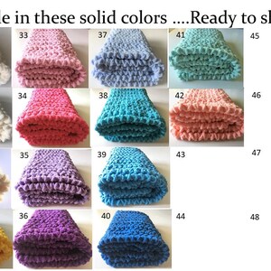 May include: A collection of 20 crocheted blankets in various solid colors, including white, pink, red, purple, blue, and yellow. The blankets are folded and arranged in a grid pattern. Each blanket is labeled with a number from 29 to 48.