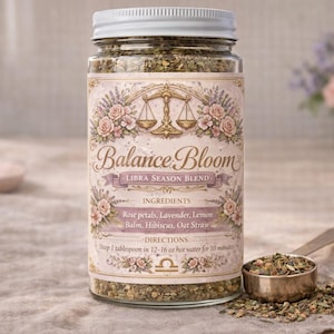 Op de afbeelding: Een glazen pot Balance Bloom Libra Season Blend thee met een witte deksel. Het etiket heeft bloemmotieven en de tekst "Balance Bloom". Een metalen lepel met theebladeren ligt naast de pot. Ingrediënten zijn rozenblaadjes, lavendel en citroen.