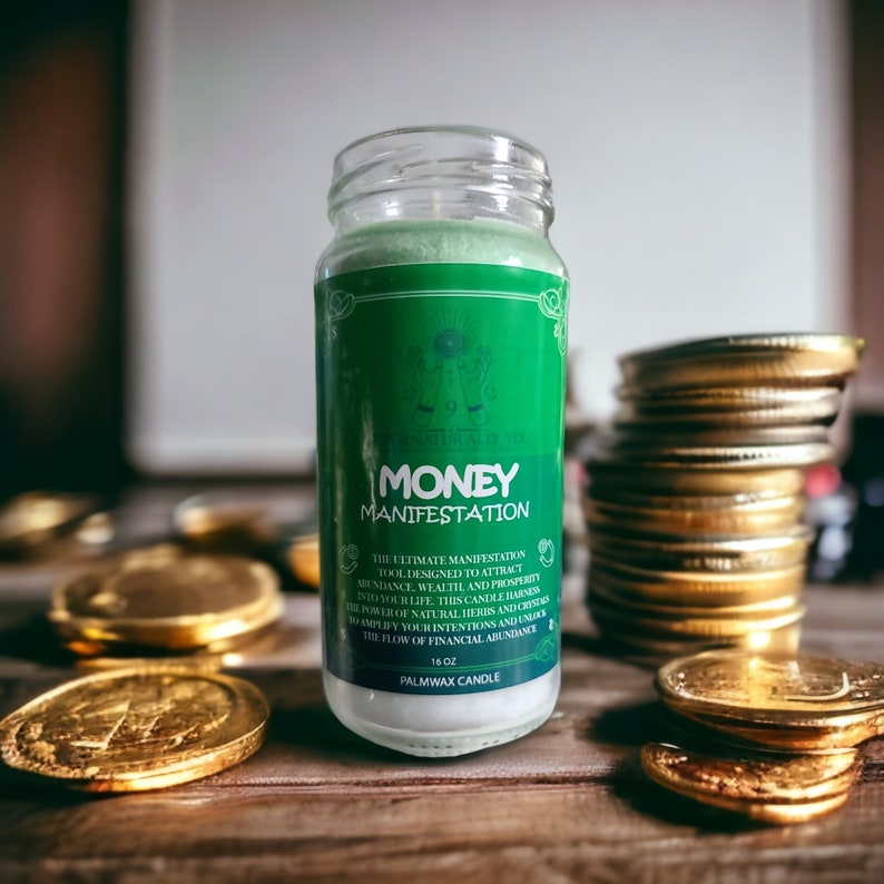 May include: A green glass candle jar with a white label that reads "MONEY MANIFESTATION". The label also includes the text "THE ULTIMATE MANIFESTATION TOOL DESIGNED TO ATTRACT ABUNDANCE, WEALTH AND PROSPERITY INTO YOUR LIFE. THIS CANDLE HARNESS THE POWER OF NATURAL HERBS AND CRYSTALS TO AMPLIFY YOUR INTENTIONS AND UNLOCK THE FLOW OF FINANCIAL ABUNDANCE." The candle is sitting on a wooden surface with gold coins scattered around it.