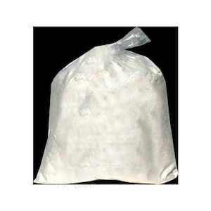 May include: A large, clear plastic bag filled with a white, powdery substance. The bag is sealed at the top with a twist tie. The background is black.