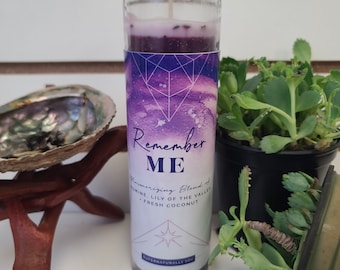 May include: Purple candle in a glass jar with a geometric design and the text "Remember ME" and "Mesmerizing Blend of Jasmine, Lily of the Valley, Fresh Coconut" and "Supernaturally You".
