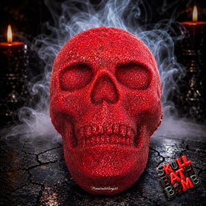 May include: A bright red, glittery skull-shaped bath bomb with a textured surface. The object features deep eye sockets, a nasal cavity, and defined teeth. The text "SKULL BATH BOMB" and "Minionbubblingbb" are visible in the lower right and center.