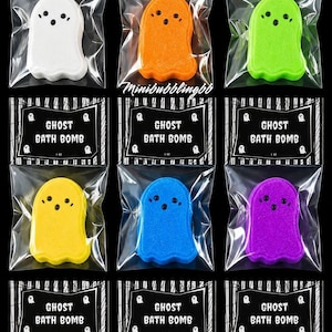 May include: Nine ghost-shaped bath bombs in individual clear plastic bags with black labels reading GHOST BATH BOMB. The bath bombs come in white, orange, lime green, yellow, blue, purple, pink, red, and dark blue, each with two eyes and a mouth.