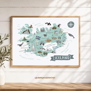 May include: A framed illustrated map of Iceland featuring various landmarks, wildlife, and the Icelandic flag. The map includes text labels for locations like Reykjavik, Akureyri, and Vatnajökull National Park, with a compass rose and ocean labels.