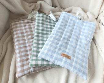 Peut inclure: Trois pochettes en tissu à motif vichy. Les pochettes sont dans les tons beige, vert et bleu clair. Chaque pochette a une petite boucle en haut. La pochette bleu clair porte une petite étiquette en cuir avec l'inscription "PEARLY DUE HANDMADE".