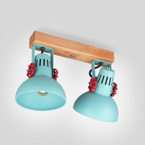 Bold loft-style light with adjustable metal shades, red valve handles, and natural wood accent