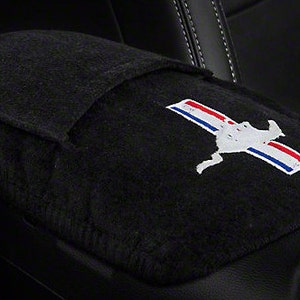 May include: Black car seat armrest cover with a black, white, and red embroidered Mustang logo.