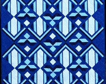May include: A blue and white geometric quilt with a repeating pattern of diamonds and stripes. The quilt is made of fabric with a textured surface.