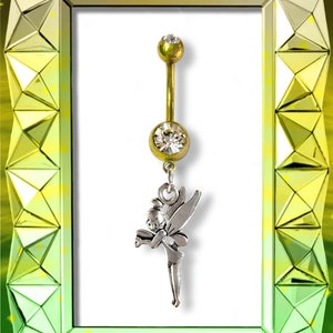 Puede incluir: Anillo de ombligo dorado con un dije de cristal transparente y un dije de hada de plata.