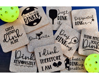 May include: Ten different designs for cork coasters featuring various pickleball-themed sayings. The coasters are made of cork and have a natural brown color. The designs are printed in black ink. The sayings include "I'm a heavy dinker", "Just Dink it", "Designated Dinker", "Great Minds Dink Alike", "Dinkarita", "Day Dinkking", "Think Before You Dink", "Dink Responsibly", "I Dink Therefore I Am", and "I have a Dinkking Problem".