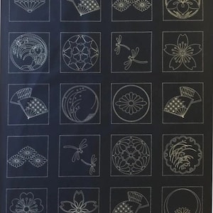 May include: A dark blue fabric panel featuring a grid of embroidered designs. The designs include flowers, fans, dragonflies, and circular patterns, all stitched in a light cream color. The overall theme is Japanese-inspired.