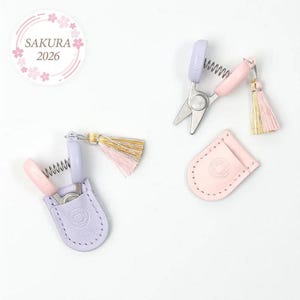 May include: A white ceramic mug with a black handle and the text "But First, Coffee" in a black, handwritten-style font. The mug is on a white surface.