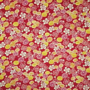 May include: Red fabric with a repeating floral pattern. The design features clusters of yellow, pink, and white flowers. The flowers are of varying sizes and shapes, creating a dense and visually rich texture.
