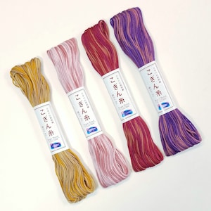 May include: Four spools of embroidery floss in different colors: yellow, pink, red, and purple. Each spool has a label with Japanese text and the words "Kepis Thread" and "Cotton 100%".