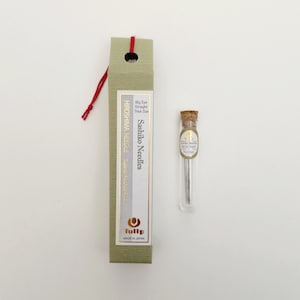 May include: A pack of Tulip Sashiko needles in a glass tube. The needles are for hand sewing and are made in Japan. The packaging is green and has the text "Sashiko Needles" and "Hiroshima Needle" printed on it.