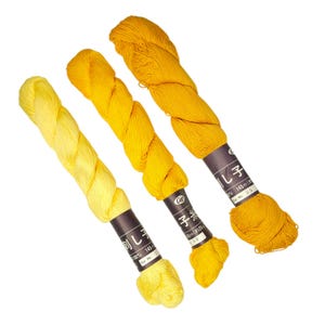 May include: Three skeins of yellow embroidery floss with labels in Japanese that read "刺し子" (Sashiko), "子米" (Kome), and "し子" (Sashiko). The labels also include the length of the floss in meters and centimeters.