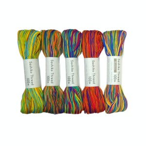 May include: Five spools of colorful Sashiko thread, each 100 meters long. The thread is made of 100% cotton and is made in Japan. The spools are labeled "Sashiko Thread 100m".