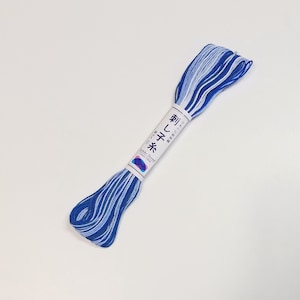 May include: A skein of blue and white embroidery floss with a label that reads "Sashiko Thread Cotton 100%" and "刺し子糸" in Japanese.