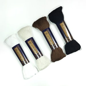 May include: Four spools of thread in white, off-white, brown, and black. Each spool is labeled with Japanese text that reads "Sashiko Thread".