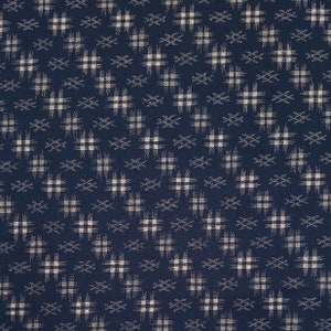 May include: A dark blue fabric with a white geometric pattern. The pattern is made up of small squares and lines that create a repeating design.