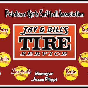 May include: A red and white sign with the text "Jay & Bill's Tire Service" in black letters. The sign is surrounded by softball-themed graphics, including a softball with the name "Isabel" on it, a softball with the name "Daisy" on it, a softball with the name "Brynn" on it, a softball with the name "Stella" on it, a softball with the name "Marybeth" on it, a softball with the name "Katie" on it, a softball with the name "Emily" on it, a softball with the name "Savannah" on it, and a softball with the name "Aurora" on it.