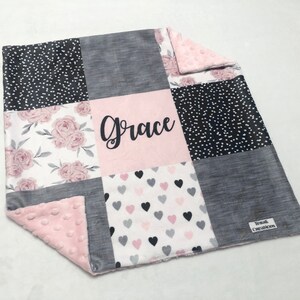 May include: A pink and gray patchwork baby blanket with a floral pattern, hearts, and polka dots. The blanket is personalized with the name "Grace".