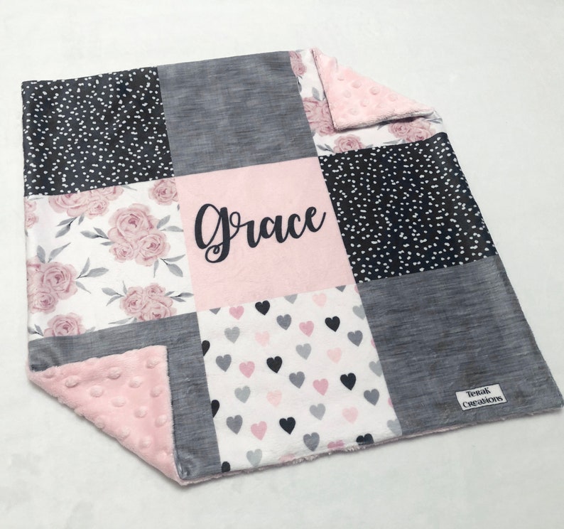 May include: A pink and gray patchwork baby blanket with a floral pattern, hearts, and polka dots. The blanket is personalized with the name "Grace".