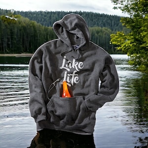 May include: A gray hooded sweatshirt with the text "Lake Life" printed in white. A bottle of orange liquid is in the pocket of the sweatshirt.
