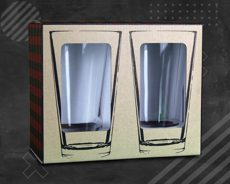 Puede incluir: Una caja de cart&oacute;n con un patr&oacute;n de cuadros en el lateral. La caja contiene dos vasos de pinta de vidrio transparente. Los vasos son visibles a trav&eacute;s de ventanas recortadas en la caja.