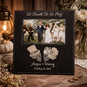 May include: A black square photo frame featuring the engraved text Til Death Do Us Part at the top. The frame displays a wedding photograph and includes an engraved illustration of two skulls wearing floral hats, the names Aaron & Stacey, and the date October 31, 2027.