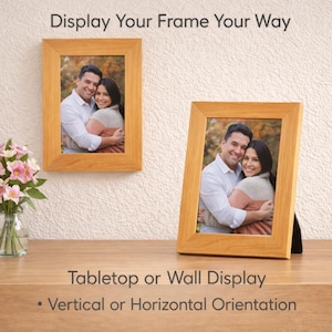 Pu&ograve; includere: Due cornici in legno, una appesa a una parete strutturata e l'altra su una superficie in legno. Ogni cornice contiene una fotografia di una coppia. Il testo in alto recita "Display Your Frame Your Way". Il testo in basso recita "Tabletop or Wall Display - Vertical or Horizontal Orientation".